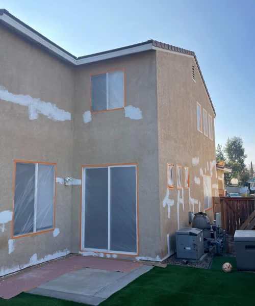 House exterior with patching and priming for painting.
