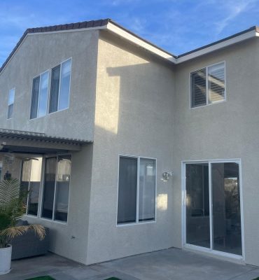 Two-story house with new exterior paint and large windows, showcasing professional residential paint.