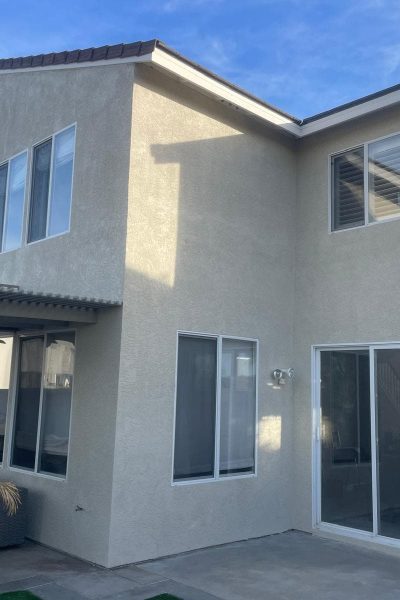 Two-story house with new exterior paint and large windows, showcasing professional residential paint.